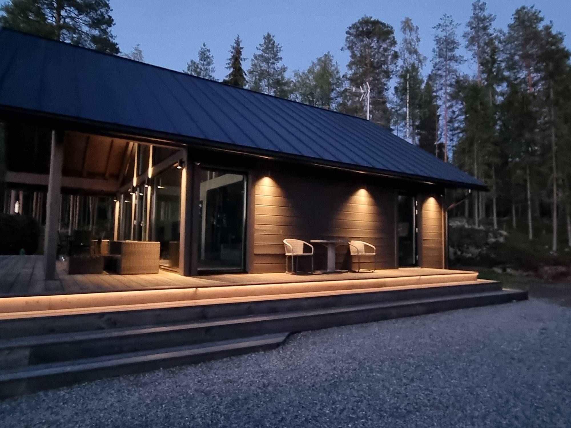 Eclairage extérieur de l\'escalier avec une lumière indirecte, accentuant l\'espace en hauteur avec des appliques bidirectionnelles. Le côté inférieur est éclairé par des versions unidirectionnelles du même luminaire. Ledstore.fi
